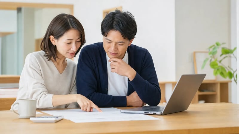 マンションの長期修繕計画書と管理費・修繕積立金の資料を確認する夫婦