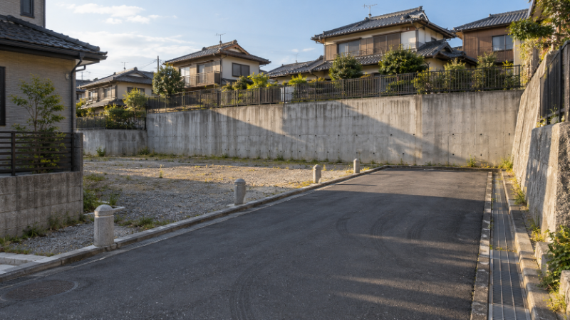 ヒナ段式に造成された住宅団地の擁壁と、数軒だけが使う行き止まりの細い私道